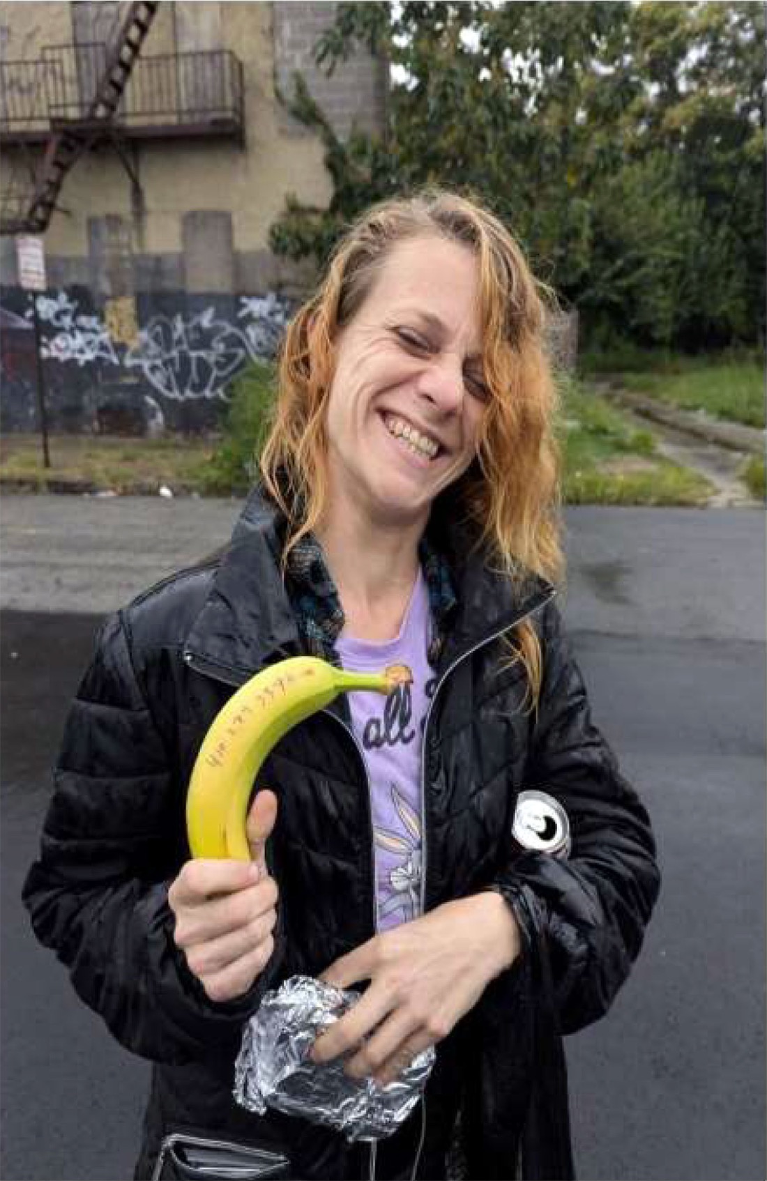 A West Baltimore neighbour smiling while holding food received from West Baltimore Help.